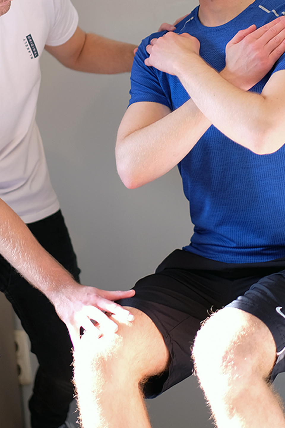 Dries De Vos helpt een patiënt met sportieve kinesitherapie bewegingen